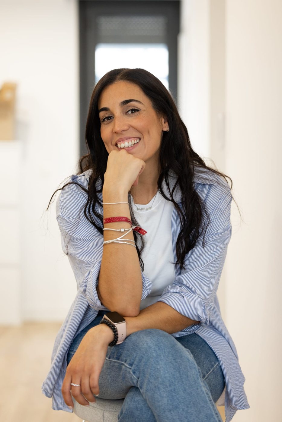 Ana Puente, psicóloga, sonriendo sentada con la mano en la barbilla